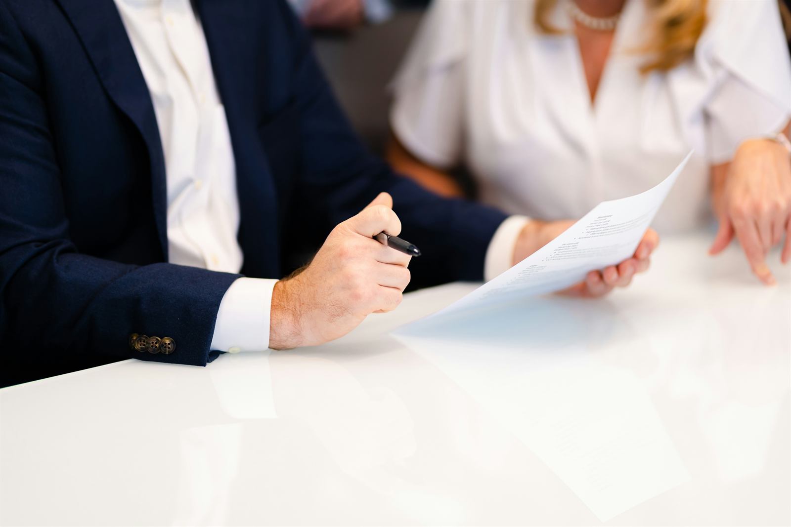 Two people reviewing and signing a document
