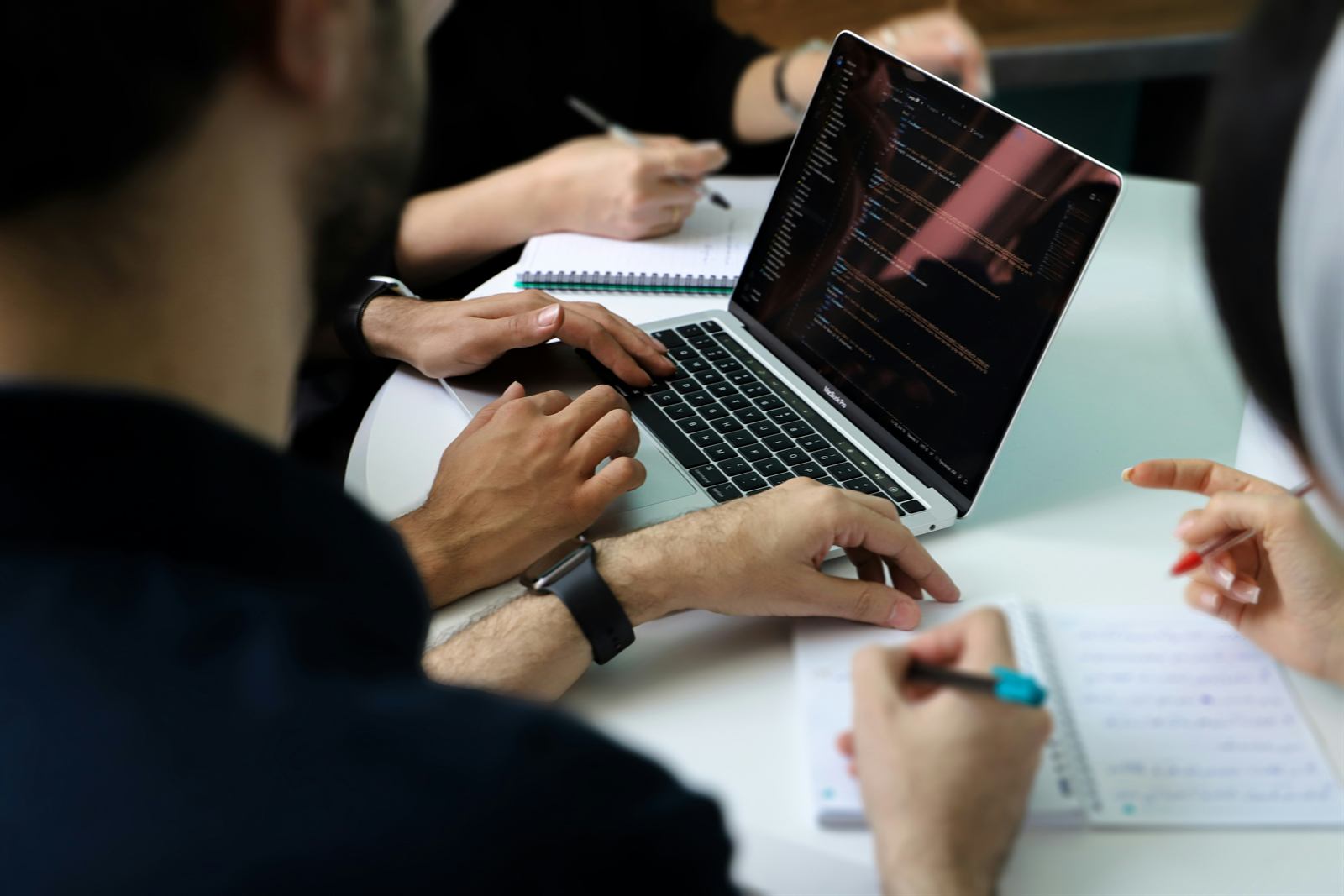 A team working through notes and a laptop in a meeting